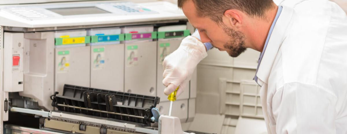 closeup shot young male technician repairing digital photocopier machine